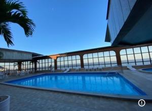 a large swimming pool in front of a building at Praia da costa vista total in Vila Velha