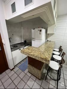 a kitchen with a counter and a refrigerator at Praia da costa vista total in Vila Velha