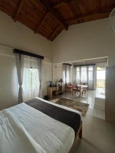 a bedroom with a large bed and a living room at The Himalayan Munros in Chaubattia
