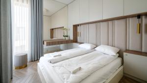 a bedroom with two beds with white sheets at Solmarina, Sun&Snow in Wiślinka