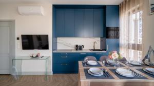 a kitchen with blue cabinets and a wooden table at Solmarina, Sun&Snow in Wiślinka