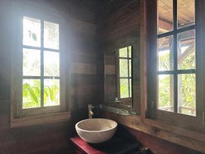 a bathroom with a bowl sink and two windows at MK Hill resort Phu Quoc in Phú Quốc