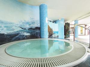 a swimming pool in a building with a painting on the wall at Hotel La Palma Romántica in Barlovento