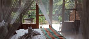 a bedroom with a bed and a large window at Ayanura Ella in Ella