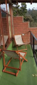 two chairs sitting on a porch with green floor at Ayanura Ella in Ella +2 photos