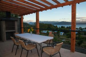 una mesa y sillas en un patio con vistas al agua en Cabañas Lomas de Ensenada, en Licán Ray