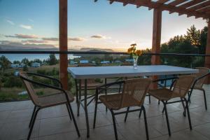 una mesa y sillas en un patio con vistas al agua en Cabañas Lomas de Ensenada, en Licán Ray