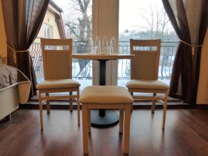 a table and two chairs with a table and a window at Villa Gdańsk in Gdańsk