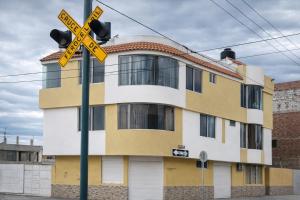a yellow and white building with a railroad crossing sign at La Casa del Turista Riobamba in Riobamba