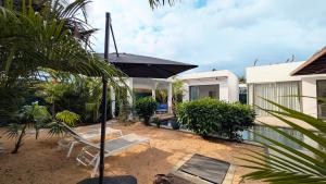 a backyard with a pool and a house with an umbrella at Villa O' in Cap Malheureux