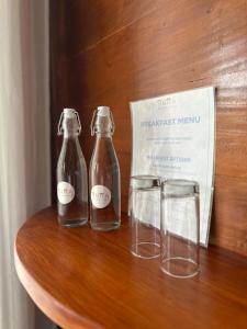 two bottles and two glasses on a wooden table at Nuna Bungalows in Riung