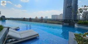 a swimming pool with a lounge chair on top of a building at Lumiere Riverside Grand Prestige Residence in Ho Chi Minh City
