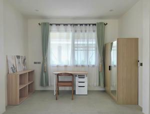 a room with a desk and a chair and a window at Neramit House in Ko Phangan