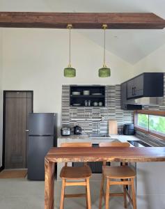a kitchen with a wooden table and a refrigerator at Neramit House in Ko Phangan