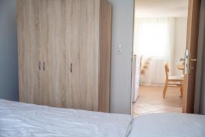 a bedroom with a bed and a wooden closet at Strandhaus 134 in Mönkebude
