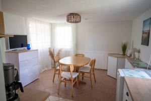 a kitchen and dining room with a table and chairs at Strandhaus 134 in Mönkebude +19 photos