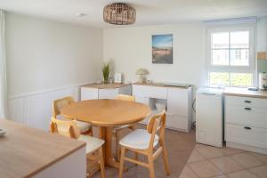 a kitchen with a table and chairs in a room at Strandhaus 134 in Mönkebude
