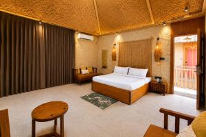 a bedroom with a bed and a couch and a table at The Ark Resort in Bhopal +3 photos