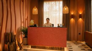 a woman standing behind a counter in a room at The Ark Resort in Bhopal