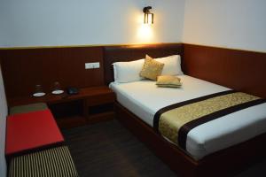 Ein Bett oder Betten in einem Zimmer der Unterkunft Juniper Residency Hotel
