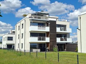 a white building with a fence in front of it at Ferienwohnung Strandblick in Großräschen