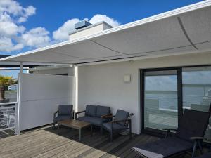 a covered deck with chairs and a table at Ferienwohnung Strandblick in Großräschen