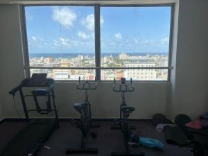 a room with three exercise bikes and a large window at Modern studio apartment in Mogadishu