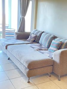 a couch sitting in a living room next to a window at Stay Joy coastal in Margate