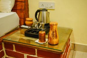 a table with a coffee maker on it at Camp Hornbill Corbett in Rāmnagar