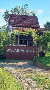 a house with a gate with the words waugh winery on it at Casa Wylak Winery in Uileacu de Criş