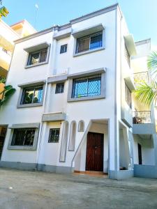 a white building with a red door at Diddy & Eddy's apartment in Malindi