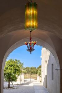 a chandelier hanging from a ceiling with a tunnel at Masseria LOGGIA PUCCI in Torre Chianca +72 photos