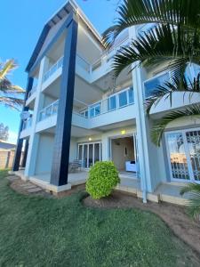 a white house with a palm tree in front of it at Stay Joy coastal in Margate