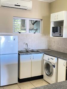 a kitchen with a white refrigerator and a washing machine at Stay Joy coastal in Margate