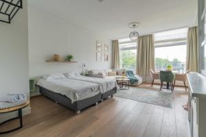 a bedroom with a bed and a living room at Job Baster Kraanplein - Het Zonnehof in Zierikzee