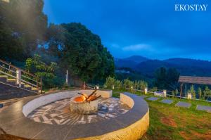 a fire pit in a park with mountains in the background at EKOSTAY I Pearl House Villa I 360 Degrees Tea Estate in Ooty
