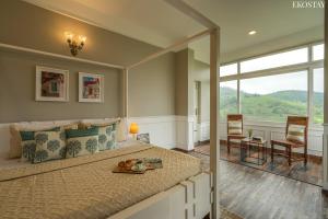 a bedroom with a large bed with a large window at EKOSTAY I Pearl House Villa I 360 Degrees Tea Estate in Ooty +30 photos