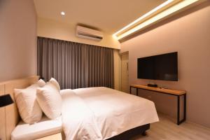 a hotel room with a bed and a flat screen tv at Cheng House in Yuchi