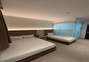 a bedroom with two beds and a blue cabinet at Coastline Hotel 6 Avenue PortDickson in Port Dickson