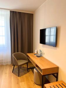 a room with a desk and a chair and a television at Schloss Hotel Zeillern in Zeillern