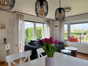 a living room with a vase of flowers on a table at Tinyhouse mit Feuerstelle Capfun de Bongerd in Tuitjenhorn