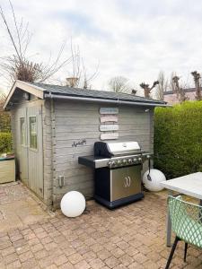 a small barbecue shed sitting on a patio at Tinyhouse mit Feuerstelle Capfun de Bongerd in Tuitjenhorn