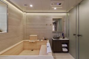 a bathroom with a tub and a sink at 웨일로 서울김포공항점 in Seoul +103 photos