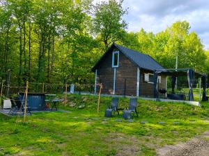 a small cabin with two chairs in a yard at 2R Relax Resort in Ubyszów