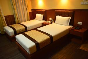Ein Bett oder Betten in einem Zimmer der Unterkunft Juniper Residency Hotel