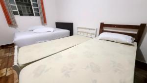 two beds sitting next to each other in a bedroom at Casa Benta in Aparecida