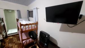 a flat screen tv hanging on a wall in a room at Casa Benta in Aparecida
