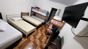 a room with three beds and a flat screen tv at Casa Benta in Aparecida