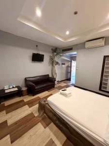 a living room with a bed and a couch at Topinn Hotel in Ban Lat Krachaeng