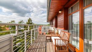 a balcony with chairs and tables on a building at Prestige Apartments Neptun Park in Gdańsk